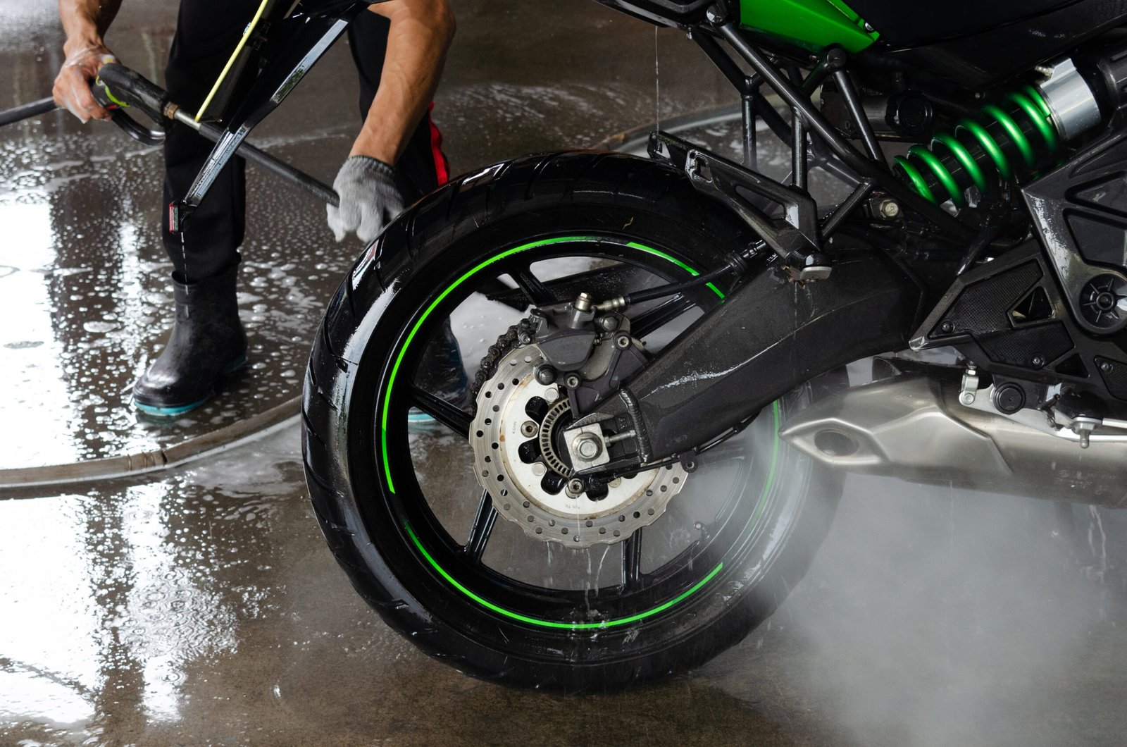 Wash motorcycle at the car wash with a high-pressure water gun.
